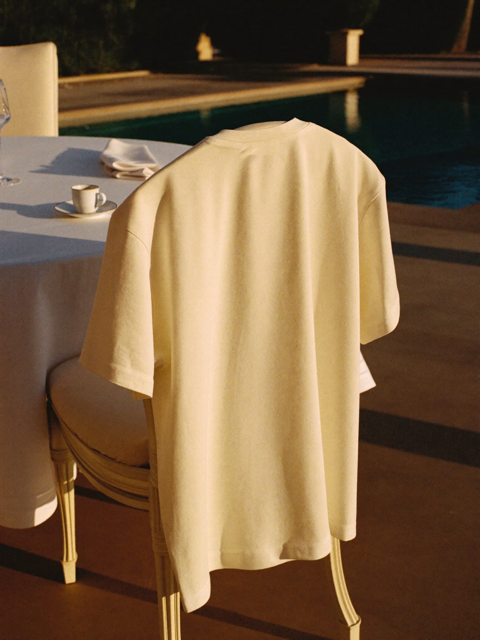 The shirt hung on the back of a breakfast chair on the villa terrace